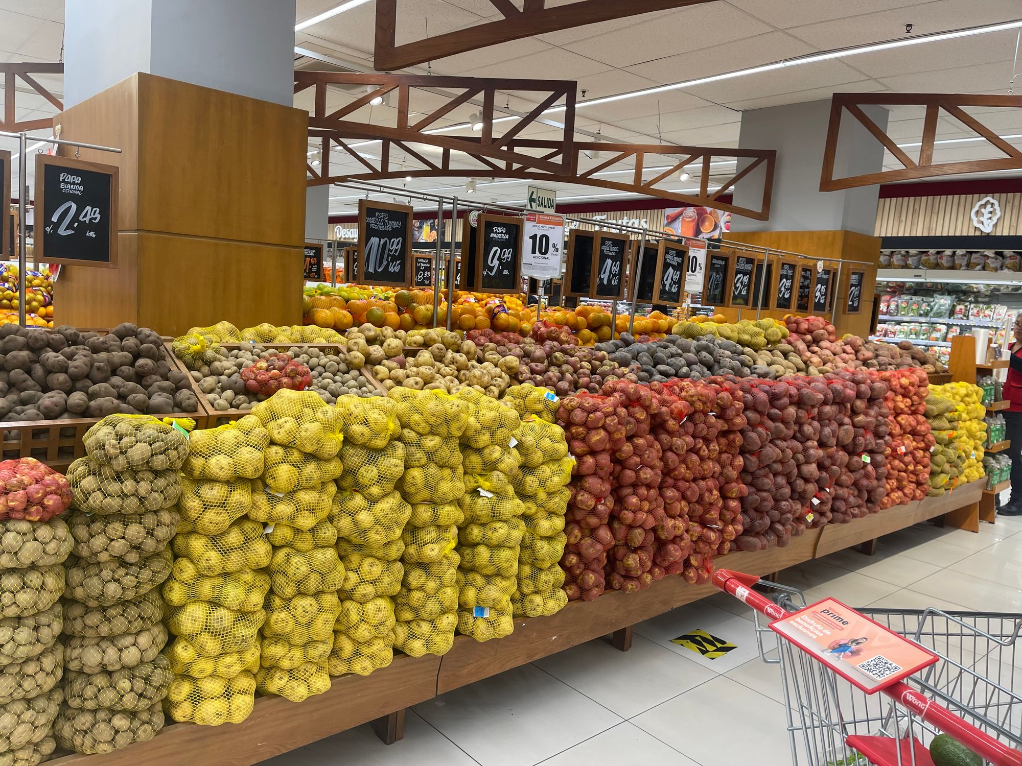 A supermarket stall full of potatoes, there are at least ten varieties of potato in different colours